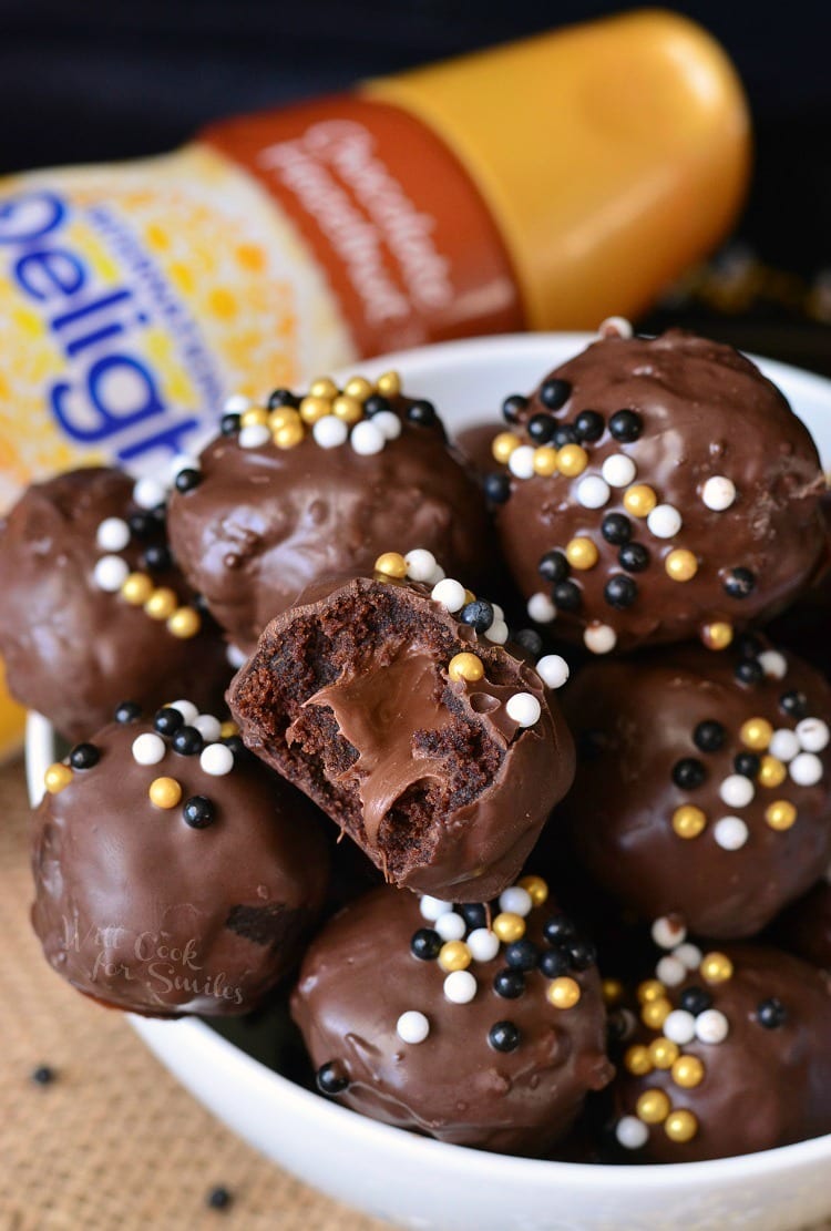 Nutella Stuffed Brownie Bites stacked up with one cut in half to show the fudgy inside in a white bowl 