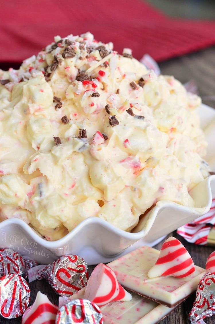 White Chocolate Peppermint Fluff Salad in a bowl with peppermint kisses around it 