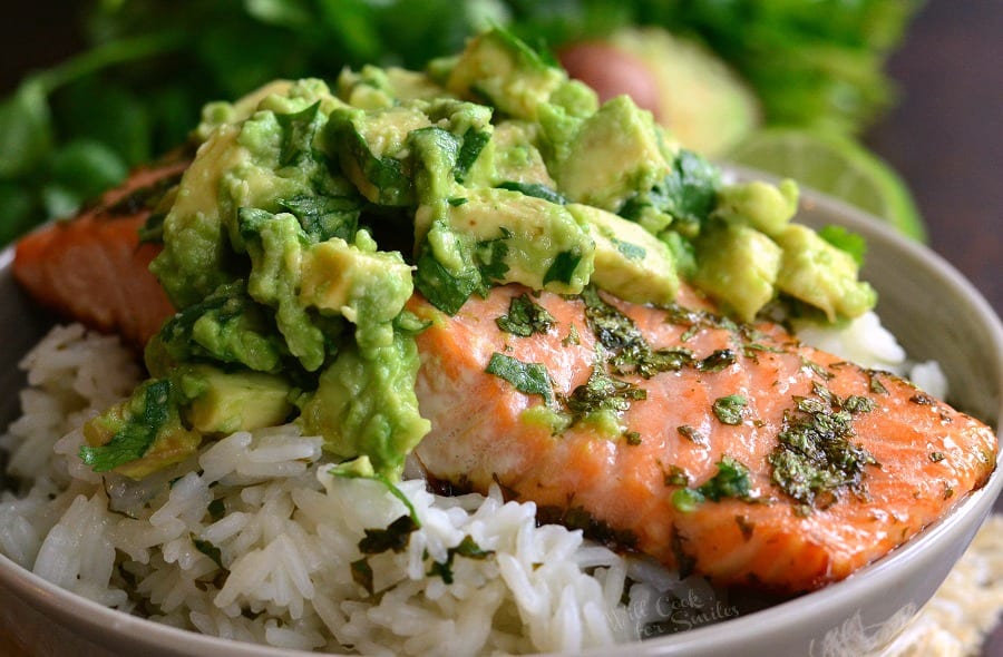 horizontal view of Salmon over Rice with avocado on top in a bowl 