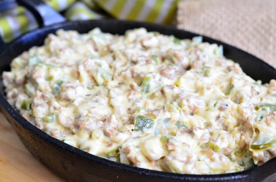 Cheesy Sausage Peppers and Onions Dip in a cast iron pan 