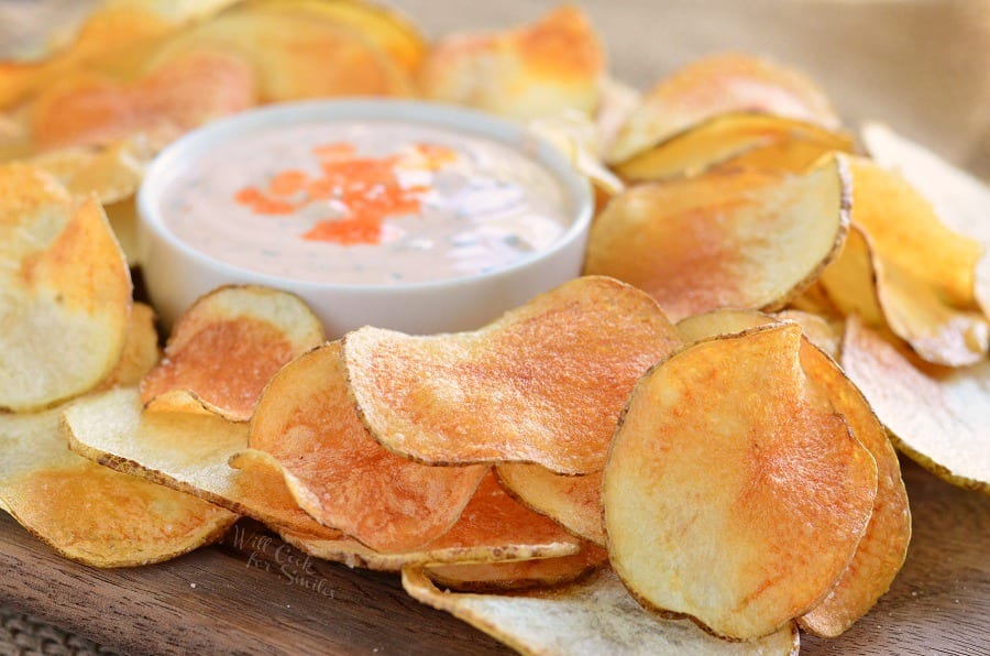 Homemade Potato Chips on a wood cutting board and Buffalo Ranch Dip in a white bowl