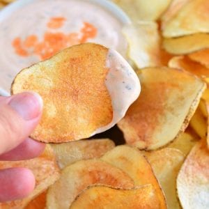 holding homemade potato chips dipped in easy buffalo ranch dip.
