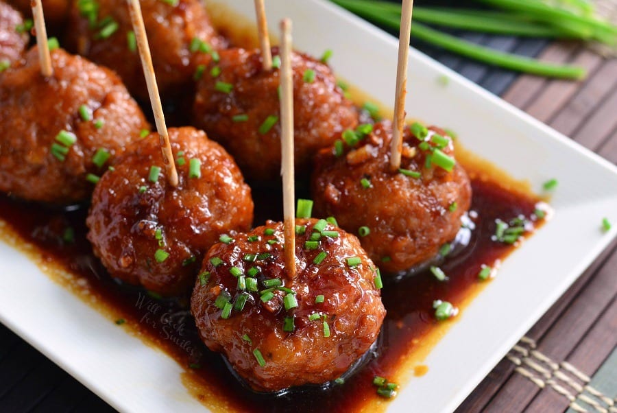 Honey Garlic Teriyaki Chicken Meatballs with toothpicks them on a white serving tray 