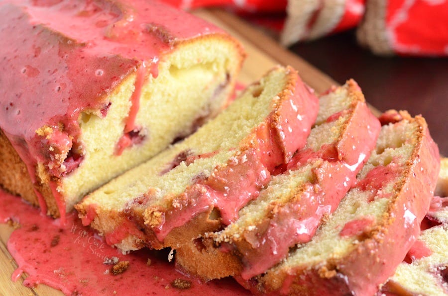 horizonal photo of pound cake cut into slices with strawberry glaze on top.