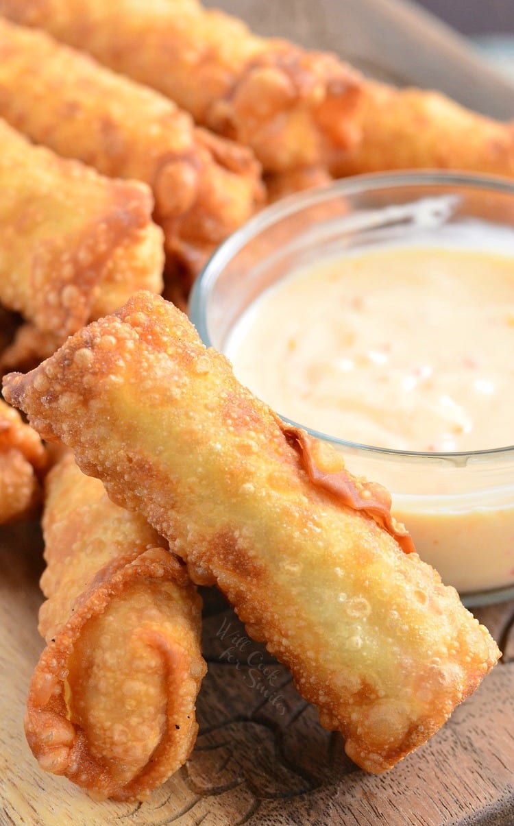 Sweet Chili Chicken Egg Rolls with Creamy Sweet Chili Sauce in a glass bowl on a cutting board 