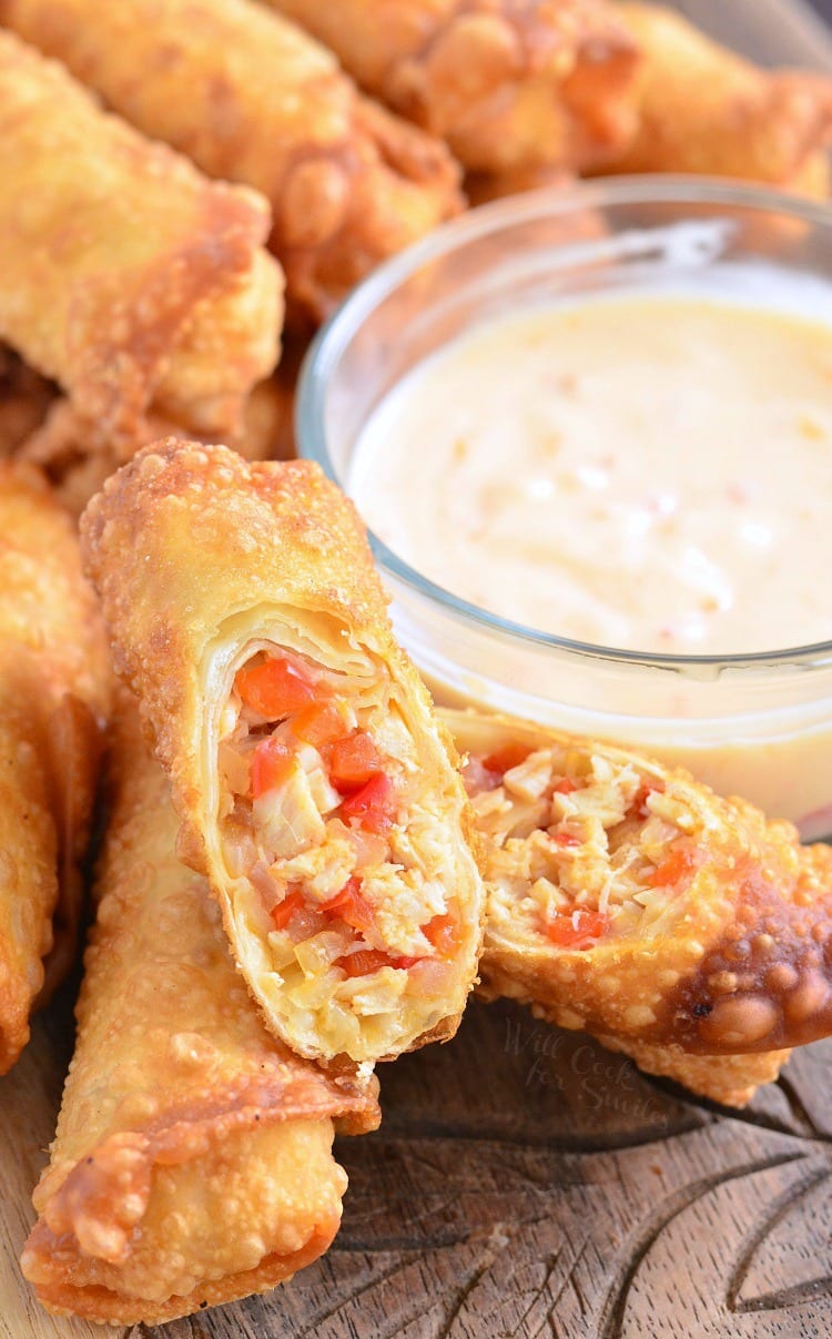 Sweet Chili Chicken Egg Rolls with Creamy Sweet Chili Sauce on a wood cutting board 