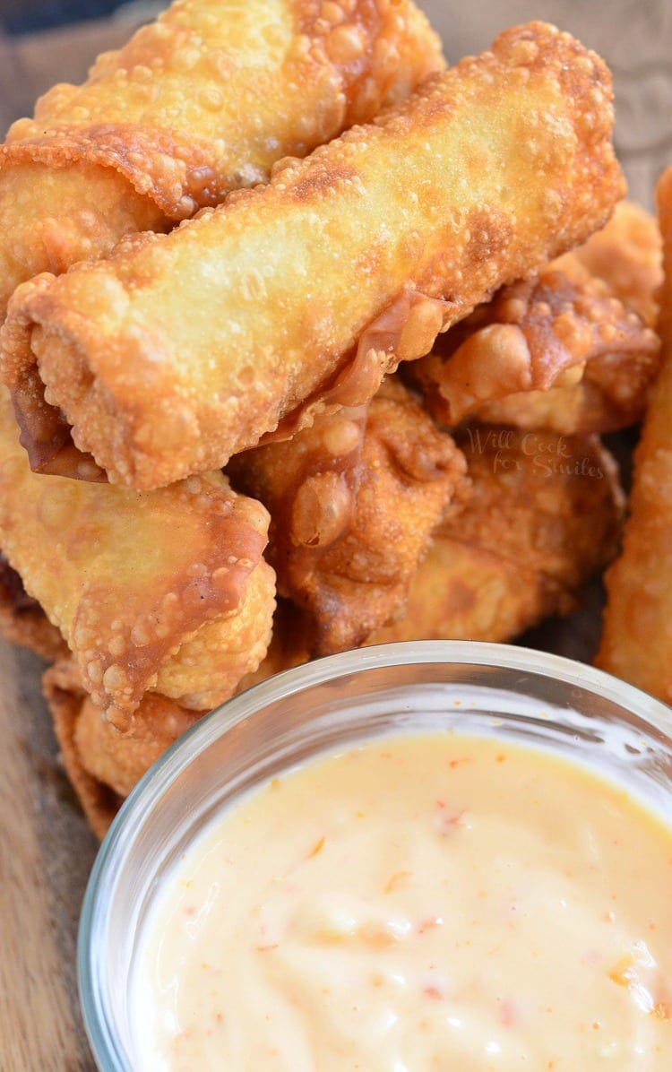 top view photo of Sweet Chili Chicken Egg Rolls with Creamy Sweet Chili Sauce in a glass bowl on a cutting board 