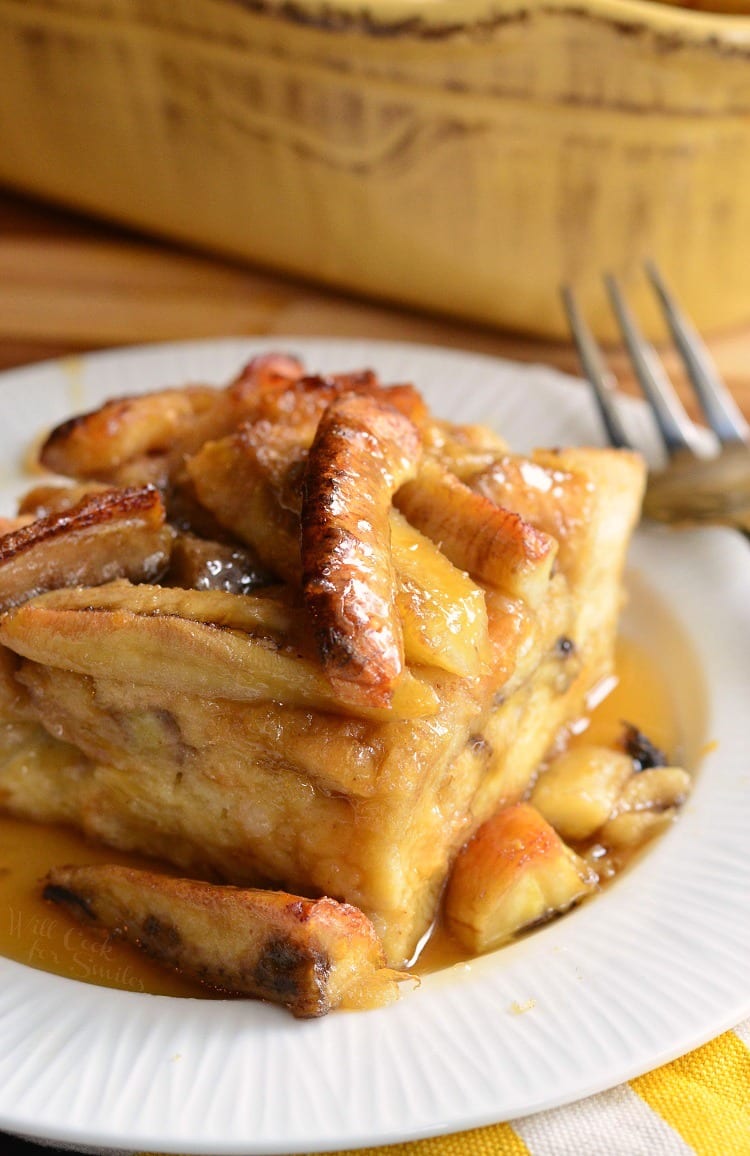 Bananas Foster Bread Pudding on a plate with syrup and fork to the right 