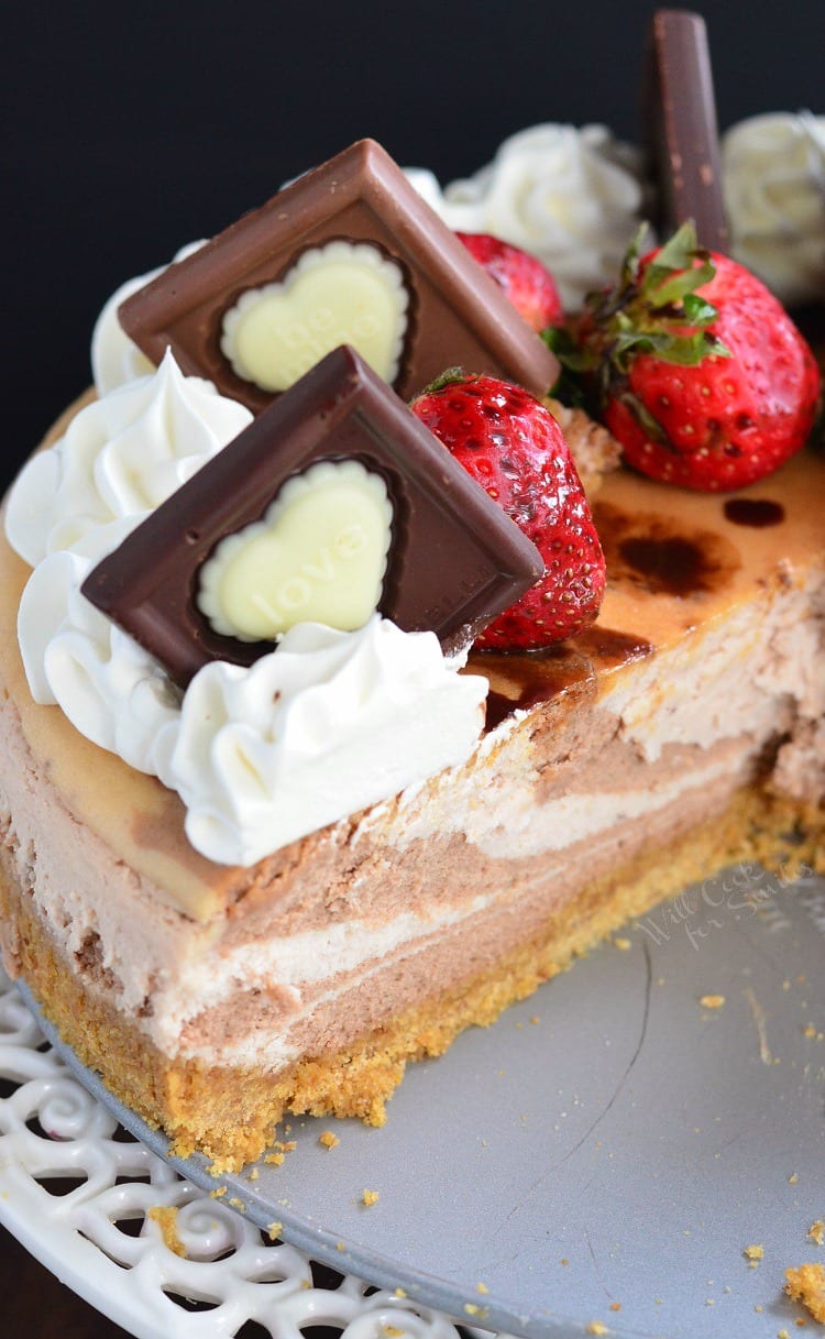 top view of Chocolate Strawberry Marbled Cheesecake with a slice missing on a cake stand 