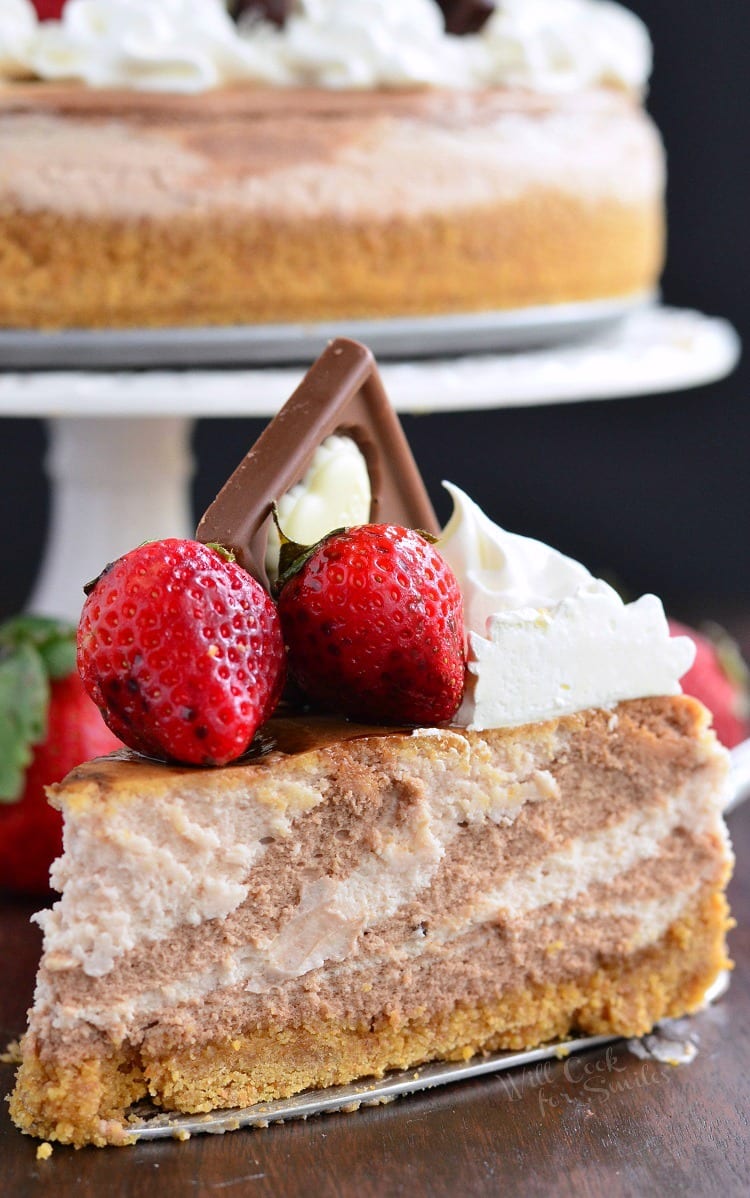 a slice of Chocolate Strawberry Marbled Cheesecake on a wood table 