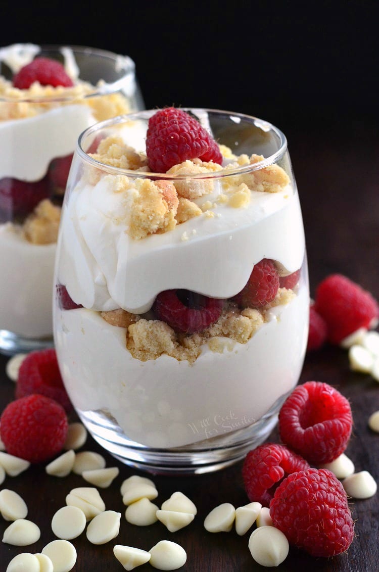 Easy Raspberry White Chocolate Mousse Parfait in a glass on a table with white chocolate chips and raspberries 