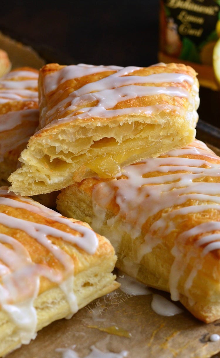 stacked Lemon Cheesecake Hand Pies on a baking sheet lined with butcher paper