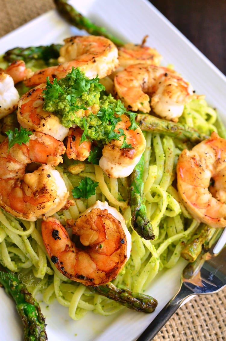 top view image Lemon Pistachio Pesto Pasta with Shrimp and Asparagus on a white plate 