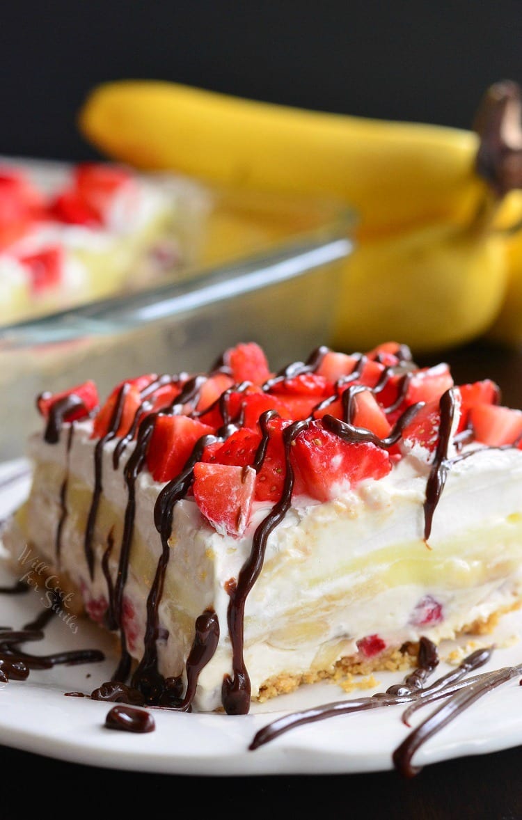 side photo of Banana Split Layered Cheesecake Dessert on a white plate 