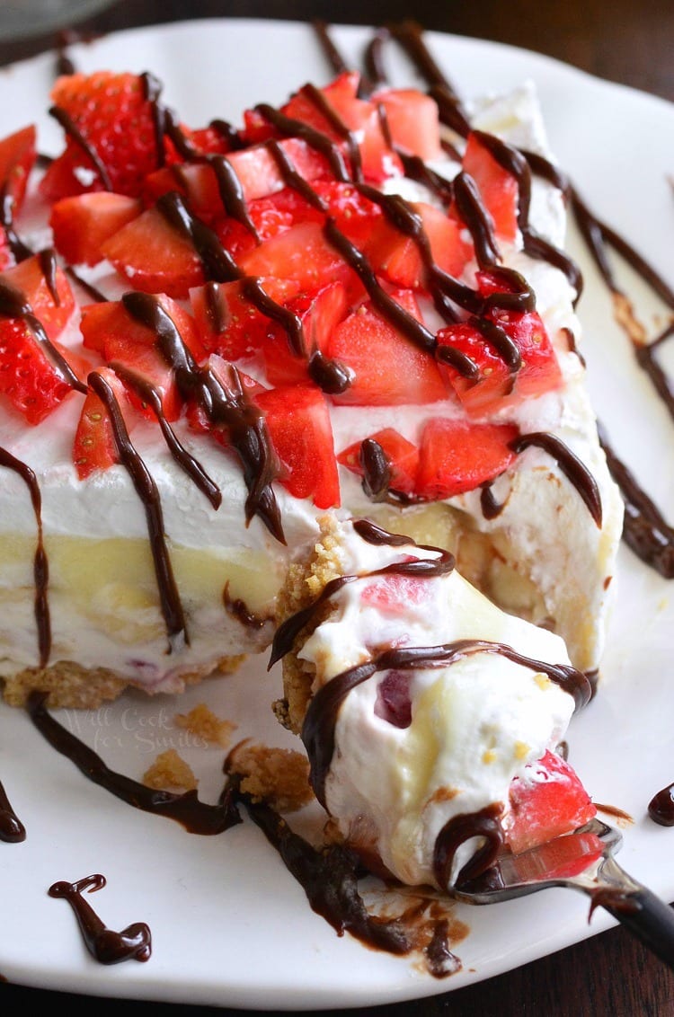 {No Bake} Banana Split Layered Cheesecake Dessert on a white plate with some on a fork 