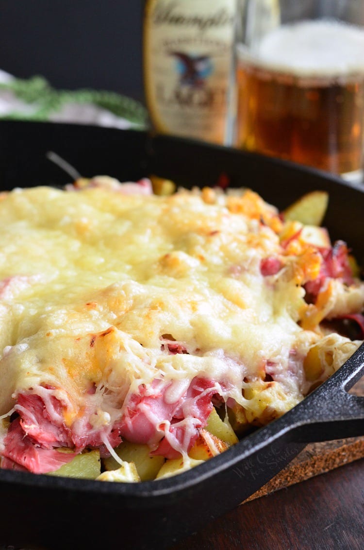 Reuben Loaded Roasted Potatoes with cheese on top in a cast iron skillet 