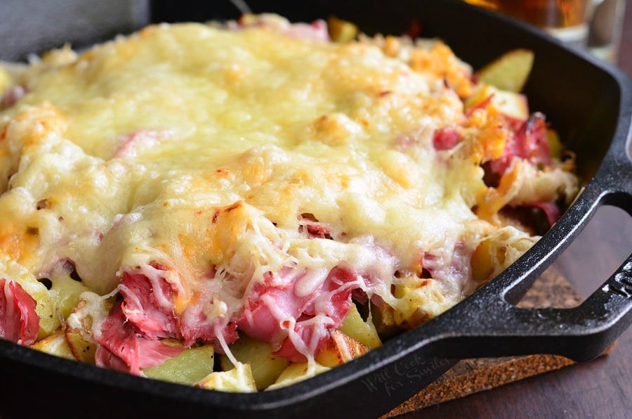 Reuben Loaded Roasted Potatoes with cheese on top in a cast iron skillet 