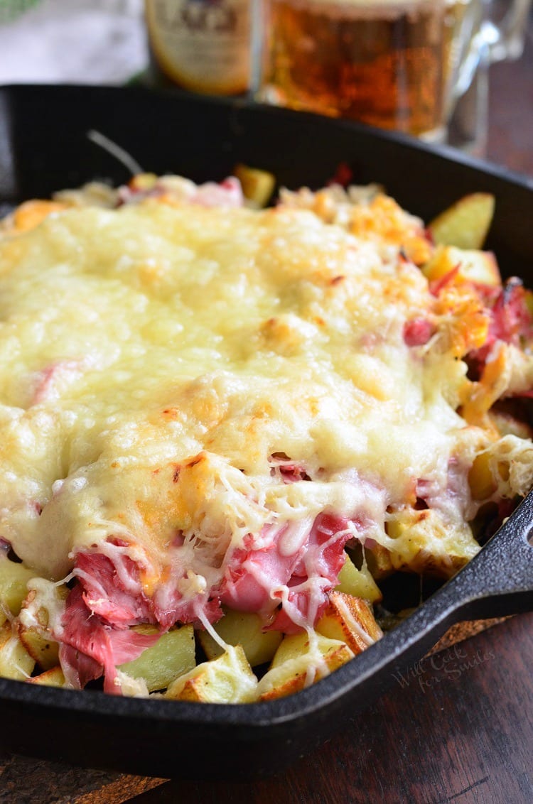 Reuben Loaded Roasted Potatoes with cheese on top in a cast iron skillet 