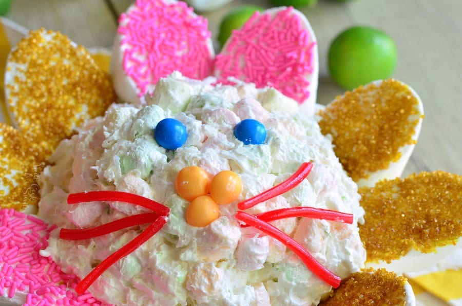 Coconut Key Lime Marshmallow Dip made into a bunny with red lickerish as whiskers and yellow skittles as a nose and blue skittles as eyes   