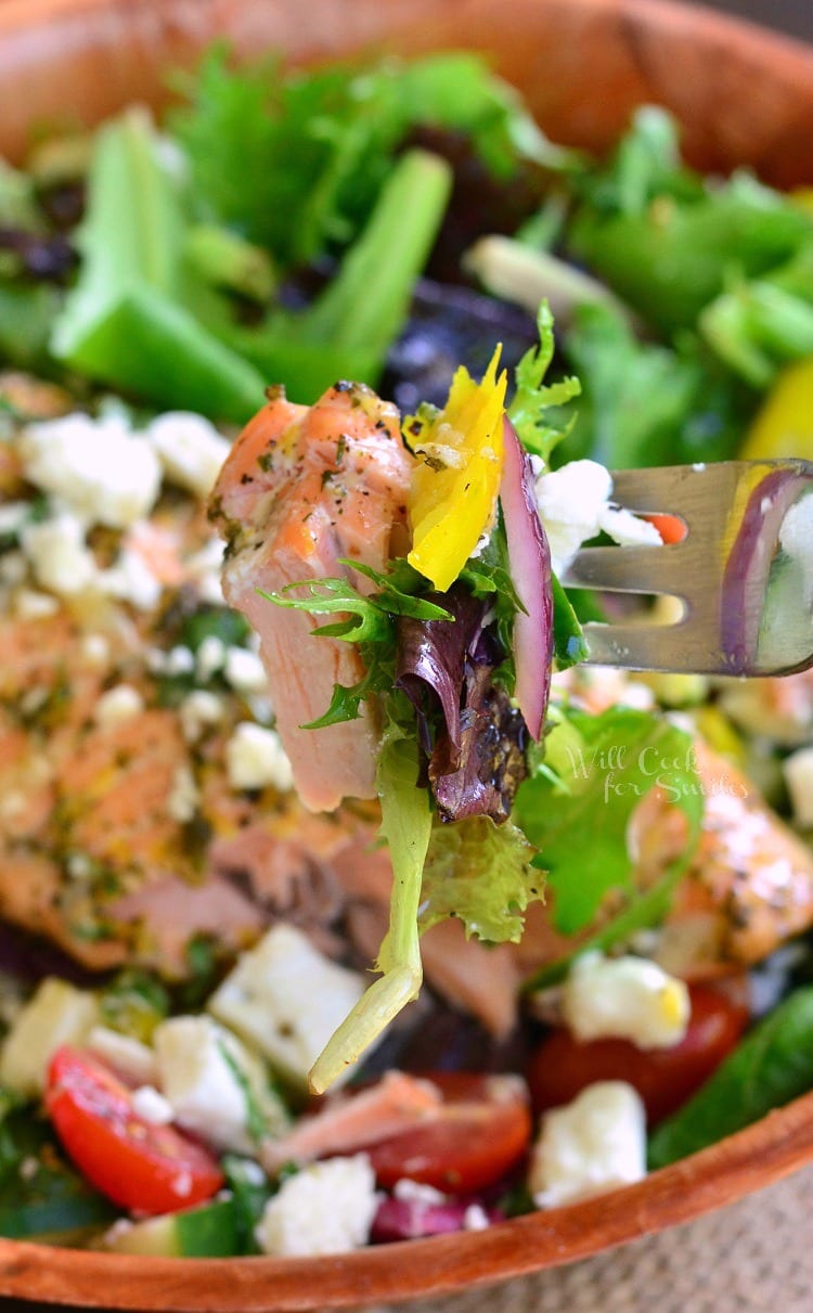 Greek Salmon Salad in a wood bowl with a some salad on a fork 