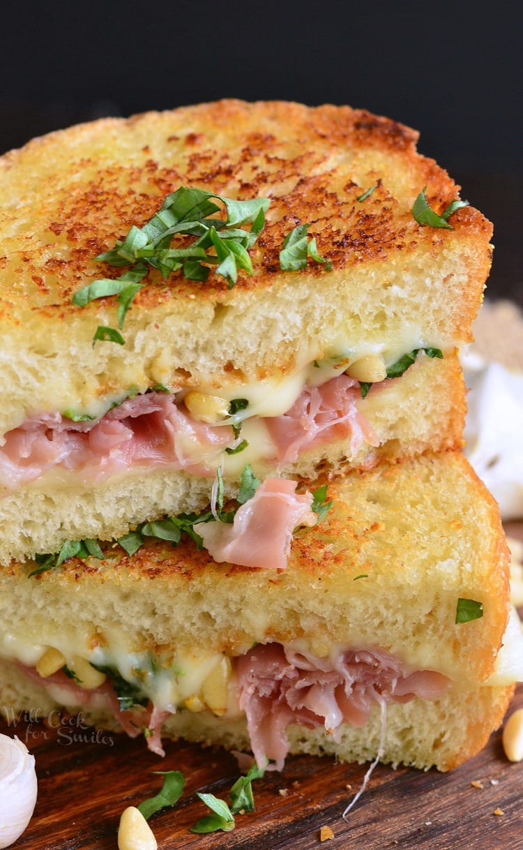 Italian Garlic Bread Grilled Cheese with ham cut in half on a cutting board 