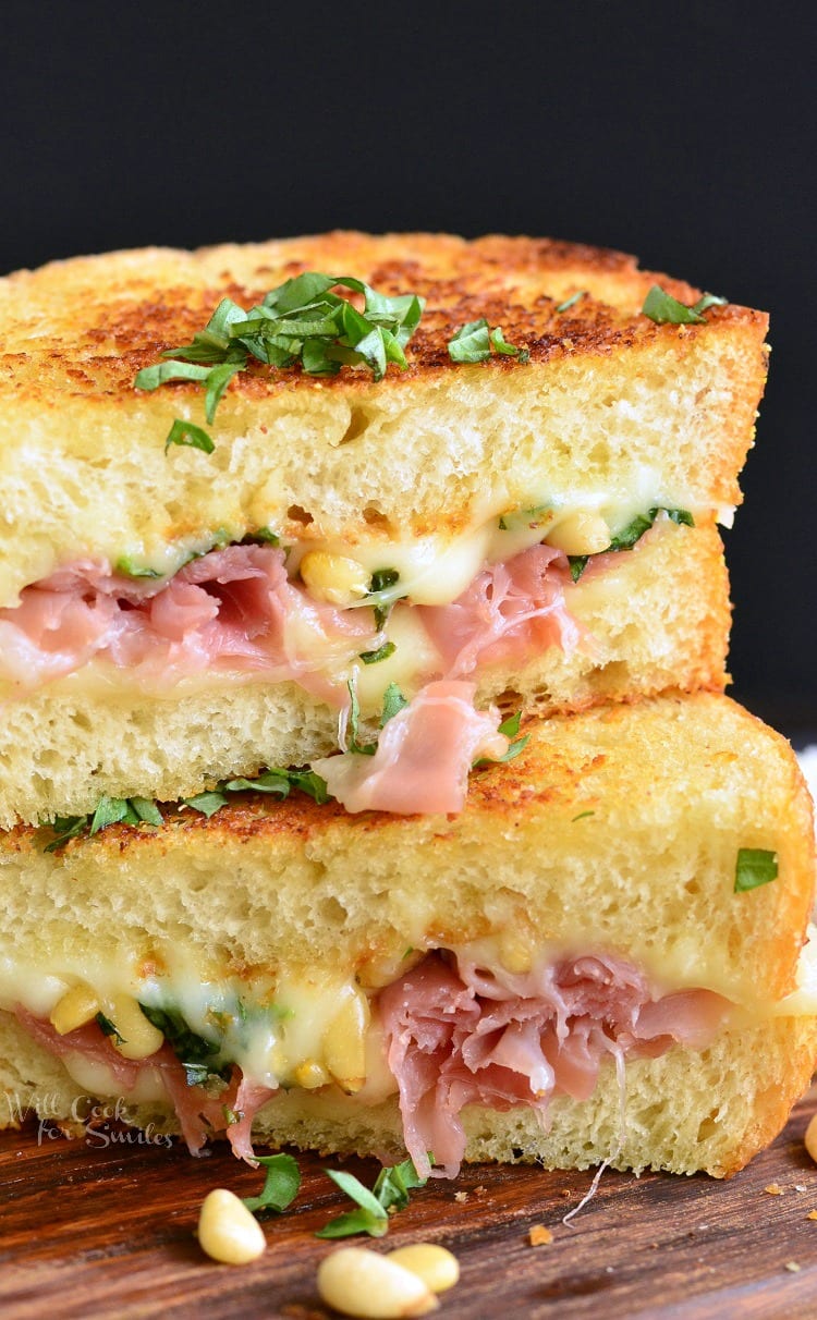 Italian Garlic Bread Grilled Cheese with ham cut in half on a cutting board 