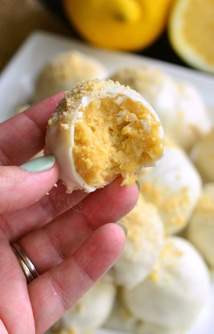 holding Lemon Oreo Coconut Cookie Truffles that have a bite taken out of them 