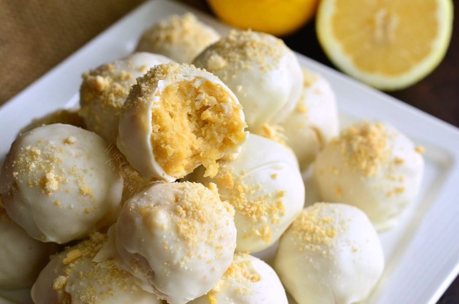 Lemon Oreo Coconut Cookie Truffles on a white plate with a bit taken out 
