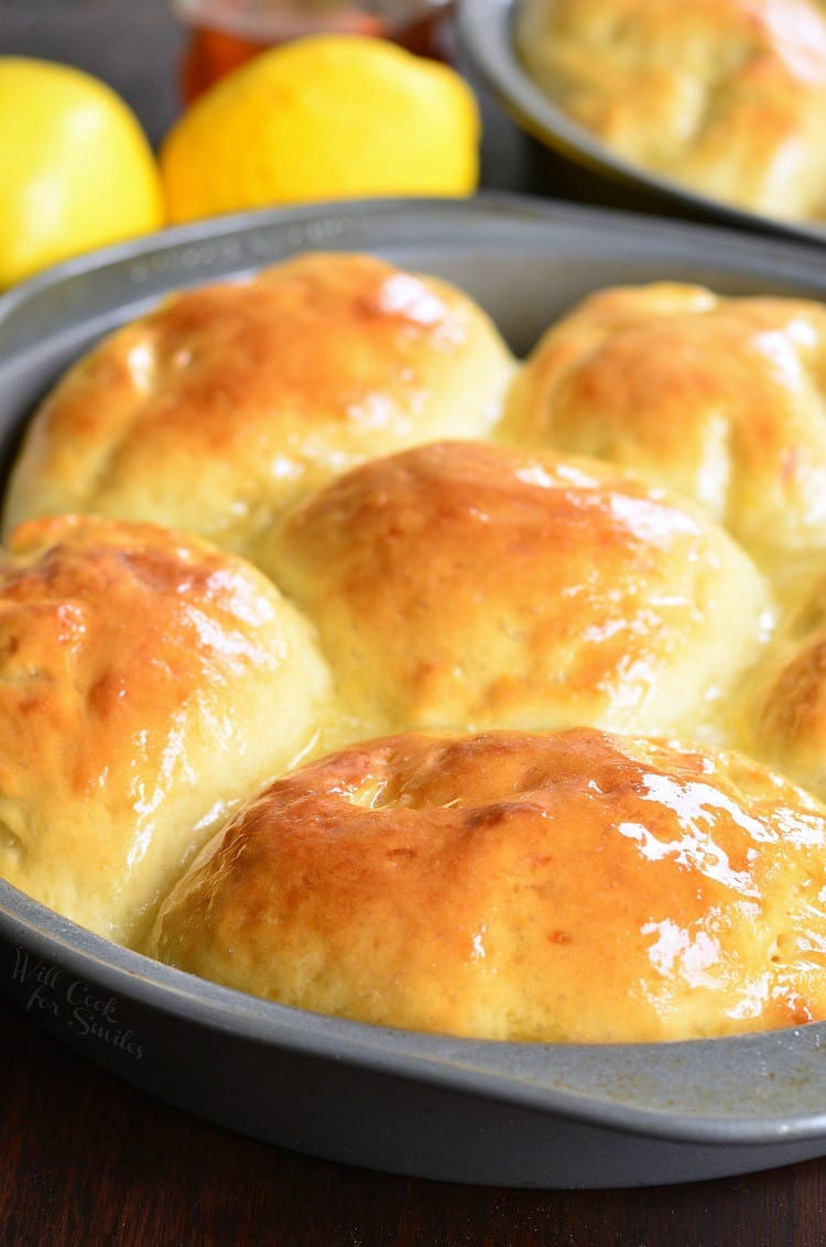 Honey Lemon Dinner Rolls in a baking dish with lemons in the background 