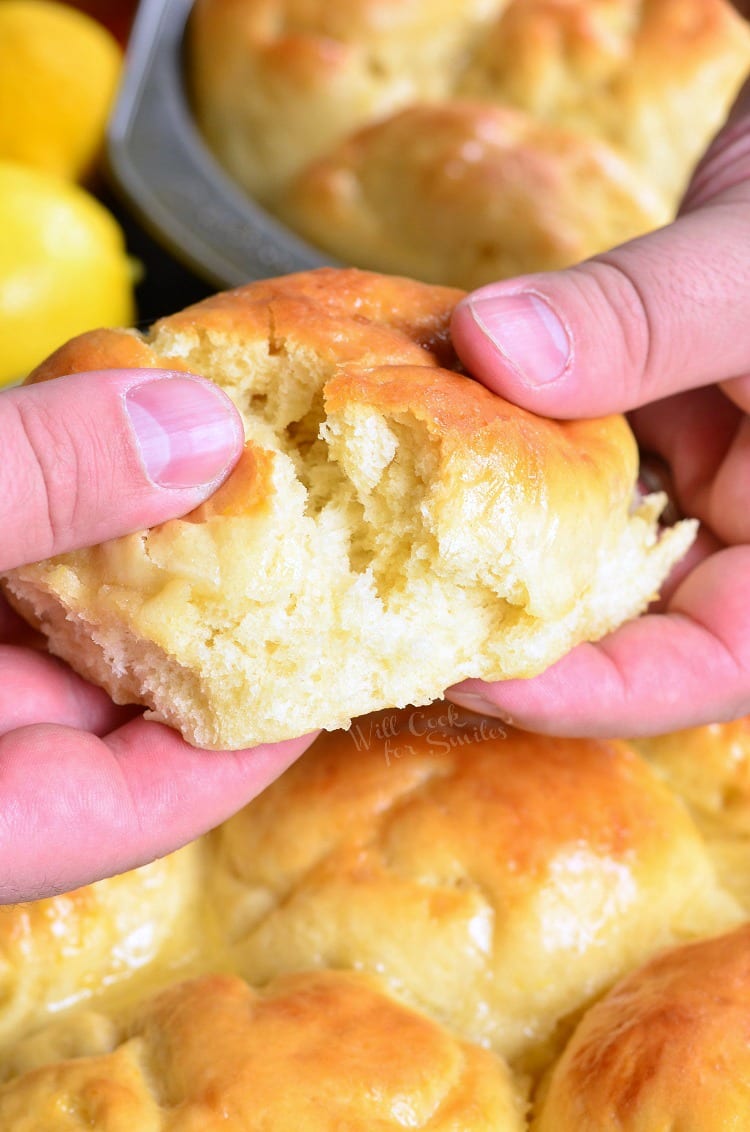 tearing a Honey Lemon Dinner Rolls in half 