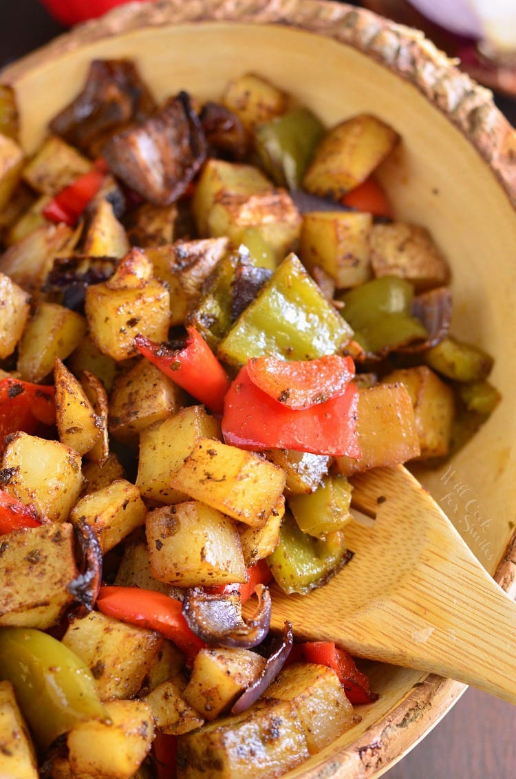 Southwest Roasted Potatoes in a yellow bowl with a wooden spoon 