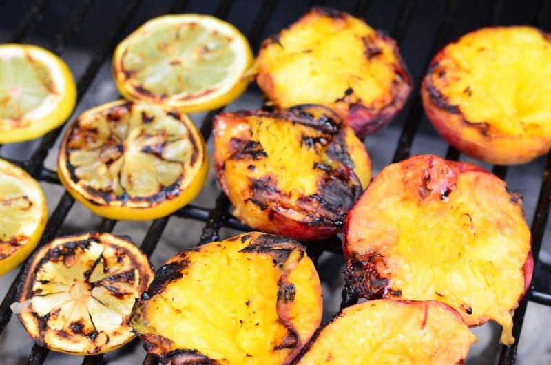 lemons and peaches on a charcoal grill 