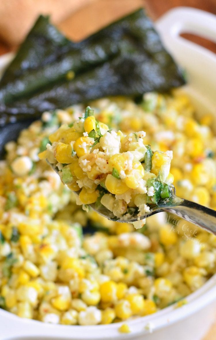 corn salad in a bowl with a fork scooping some out.