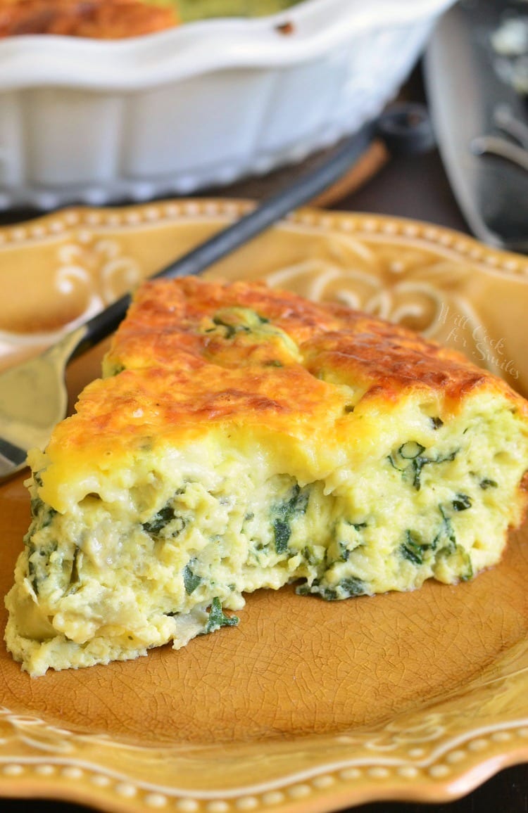 closeup of the slice of quiche on a brown plate with a fork