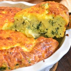 Crustless quiche in a white pie dish with a slice being cut out.