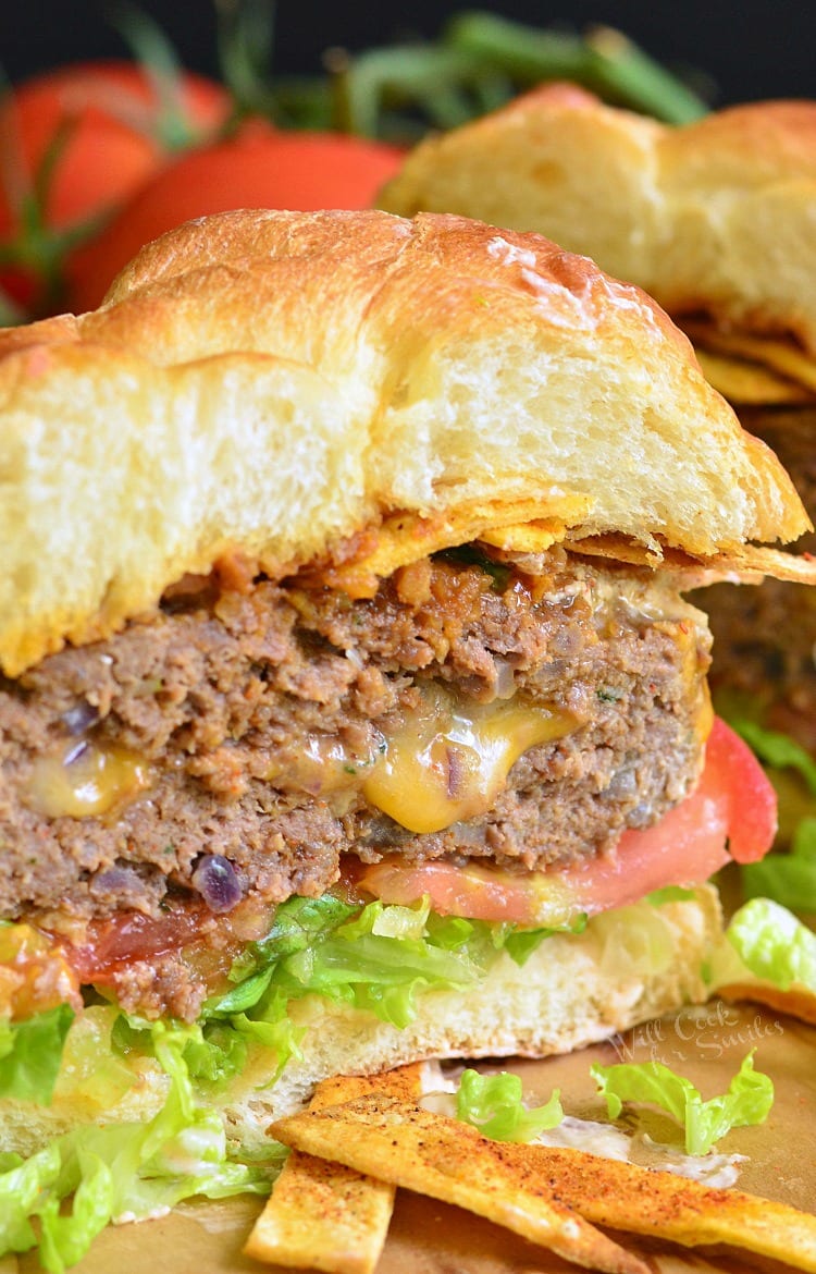 Stuffed Taco Burger cut in half on a bun with lettuce and tomato