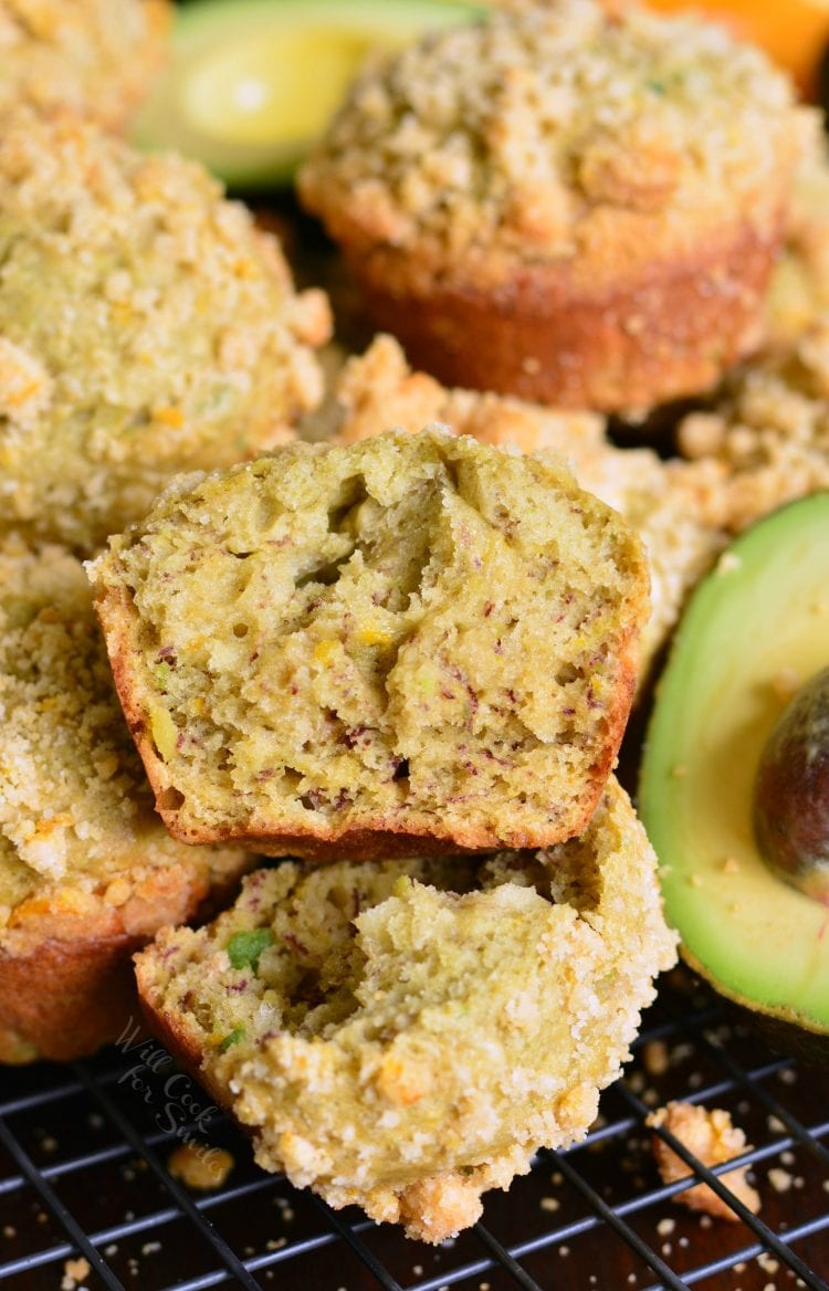Avocado Banana Muffins on a cooling rack with an avocado in the background 