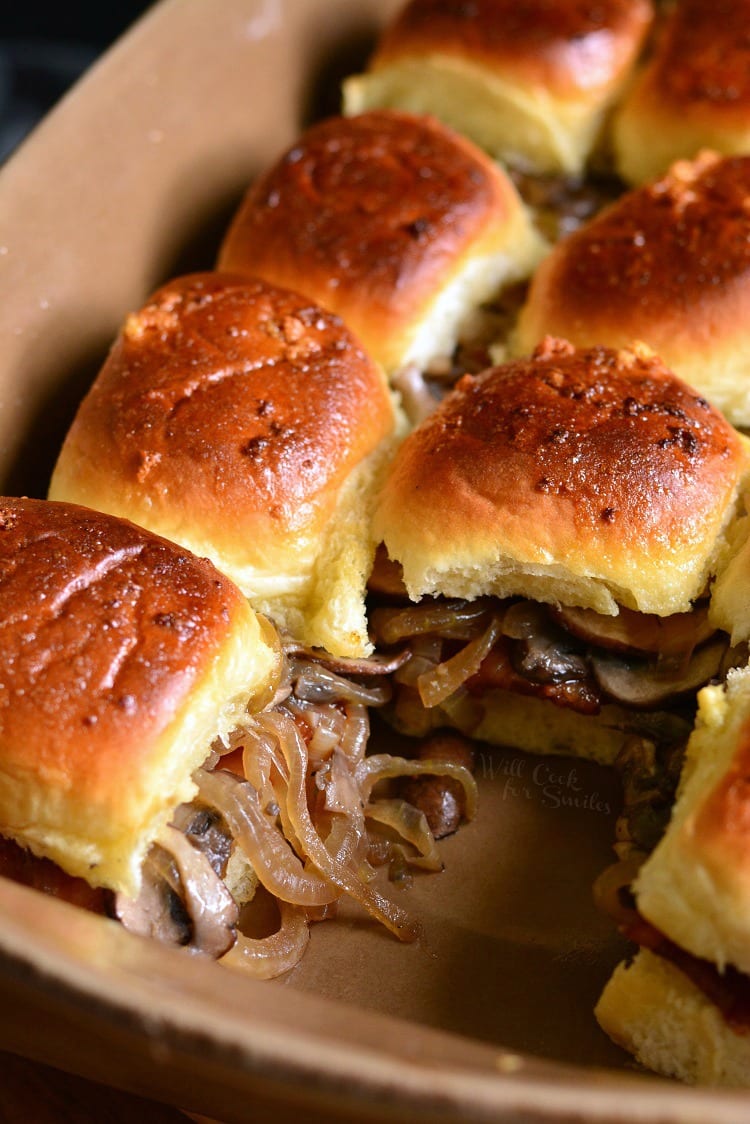 Bacon Mushroom and Onion Sliders in a baking dish with one slider gone