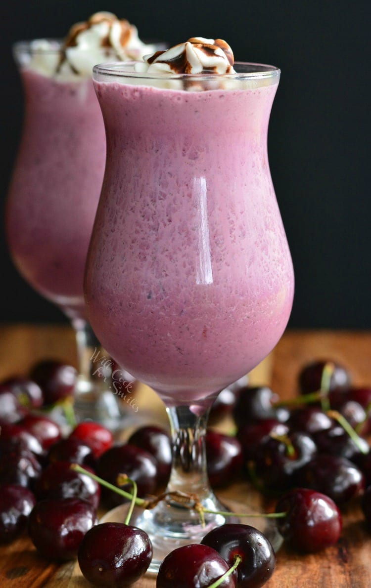 2 Chocolate Covered Cherry Milkshakes with whip cream and chocolate on top with cherries around it