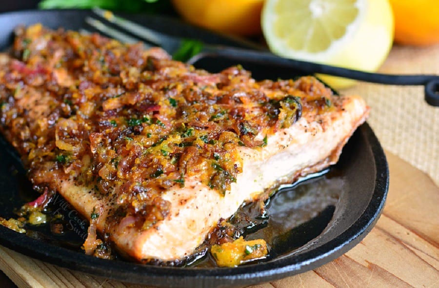 Grilled Salmon with Brown Butter Citrus Sauce on a black plate on a table 