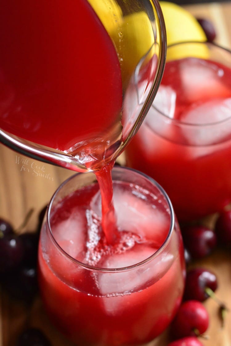 top view of pouring Homemade Cherry Arnold Palmer from pitcher into glass