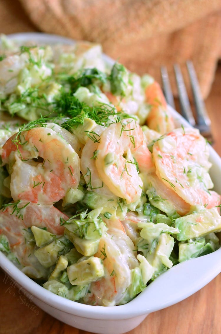 mixed shrimp salad with whole shrimp in a whole bowl with a fork next to it. 