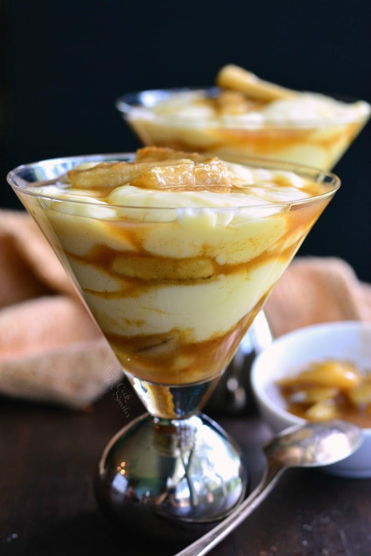 Bananas Foster Pudding Parfait in a martini class on a wood table with a spoon on the table