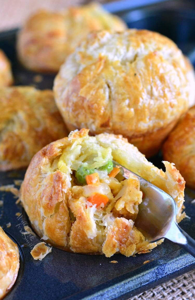 Chicken Pot Pie Pockets in a muffin tin with a fork inside 