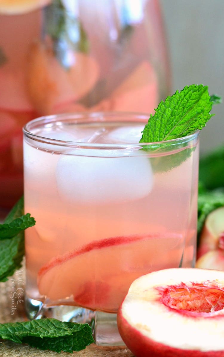 mint peach spritzer in a glass with a mint leaf as garnish.