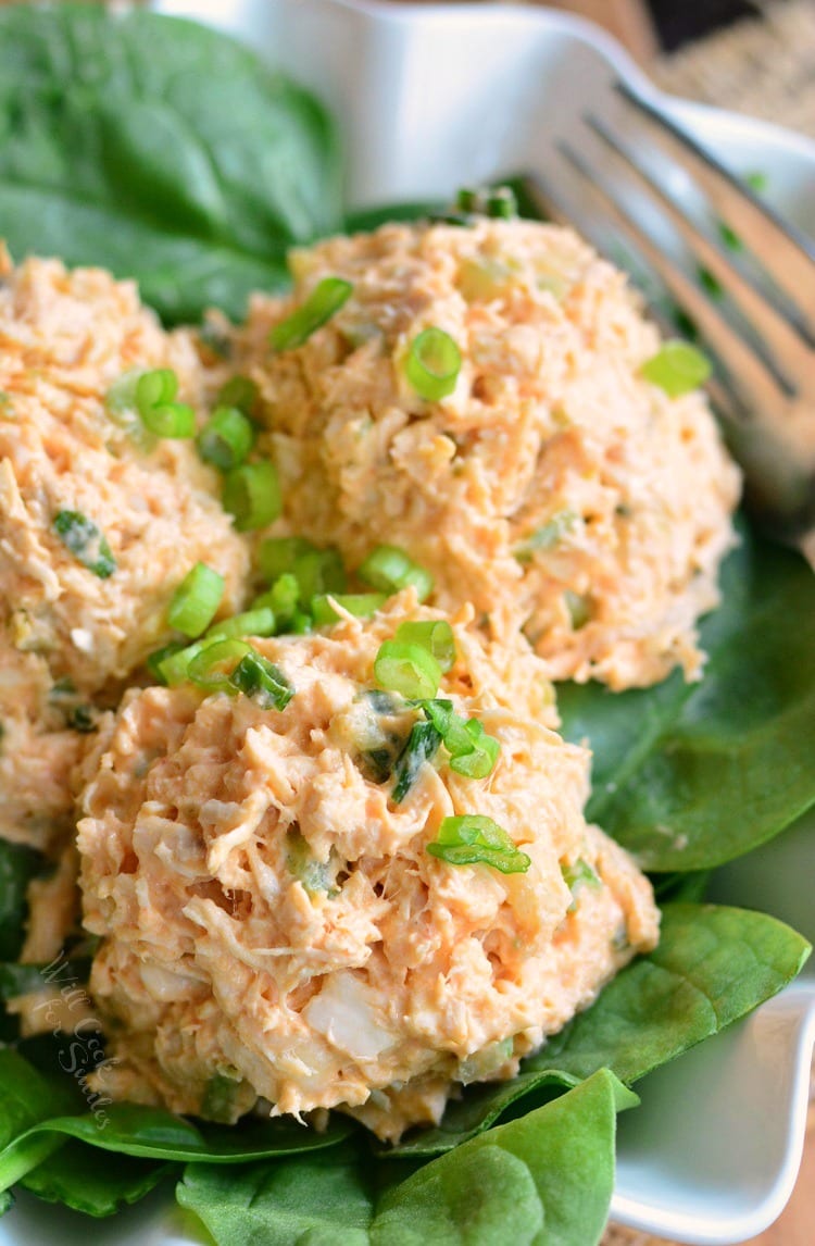 Zesty Buffalo Chicken Salad on a bed of lettuce on a plate with a fork 