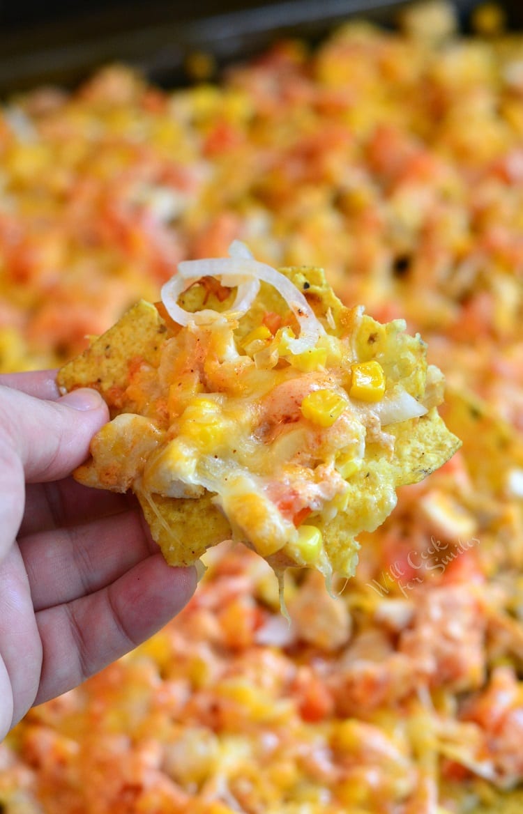 Holding a nacho from the sheet pan.