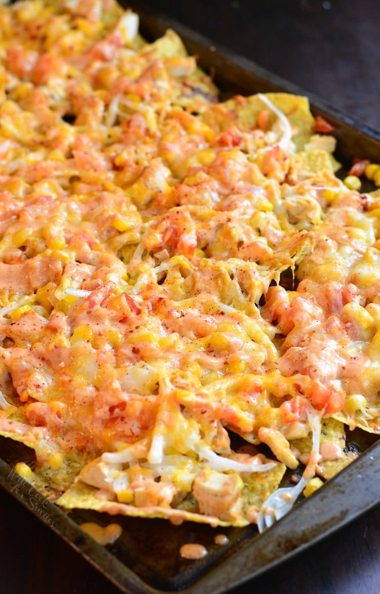 nachos on a sheet pan with cheese and chicken.