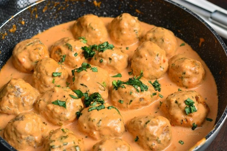 juicy and tender creamy tomato beef and pork meatballs in creamy sauce in the cooking pan.