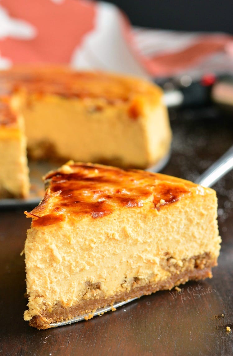 a slice of pumpkin cheesecake with bruleed topping on a spatula.